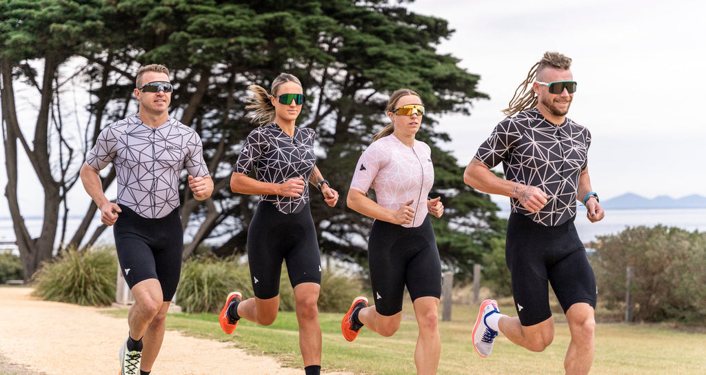 Team of athletes running, showcasing the men's and women's TRI-FIT Geo tri suits