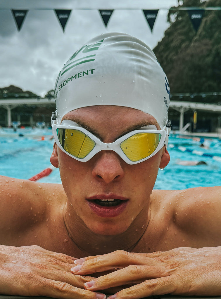Male swimmer wearing TRI-FIT RAPID-X swim goggles in white
