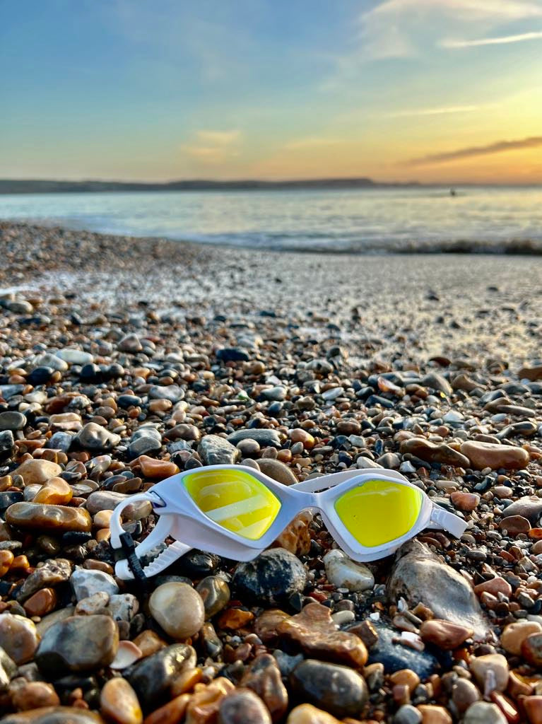 TRI-FIT RAPID-X swim goggles in white on a beach at sunset