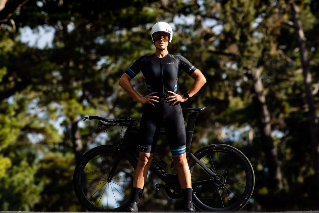 Female wearing the black EVO women's tri suit in front of a bike