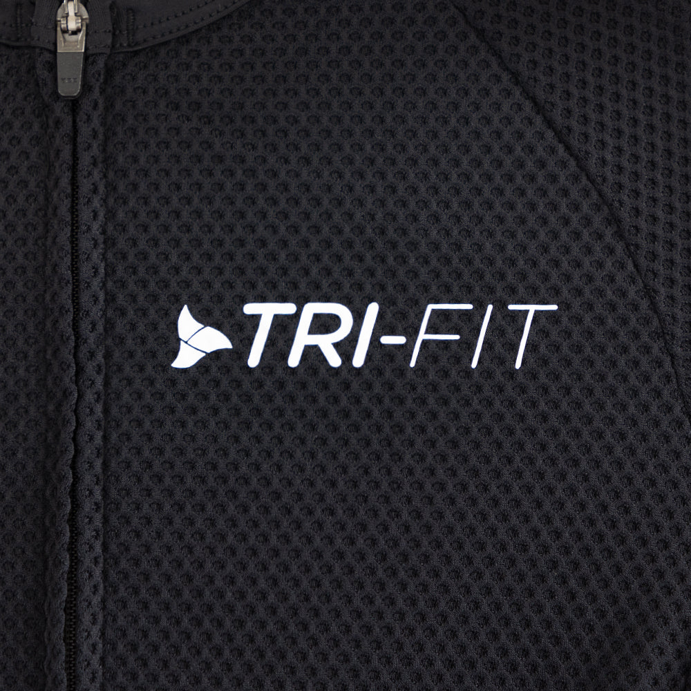Close-up of TRI-FIT logo printed on the chest of the VANGUARD tri-suit in black, showing textured breathable fabric