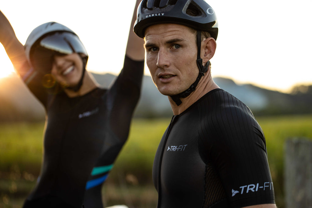 Man and woman wearing the evo tri suit with the sunset in the background